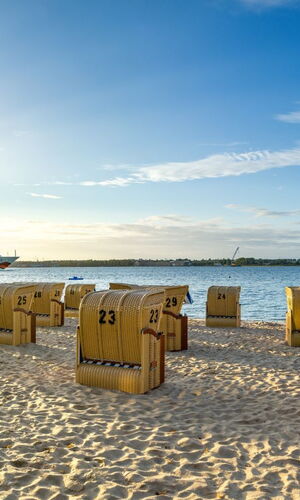 Strandkörbe an der Kieler Förde und die AIDA im Hintergrund